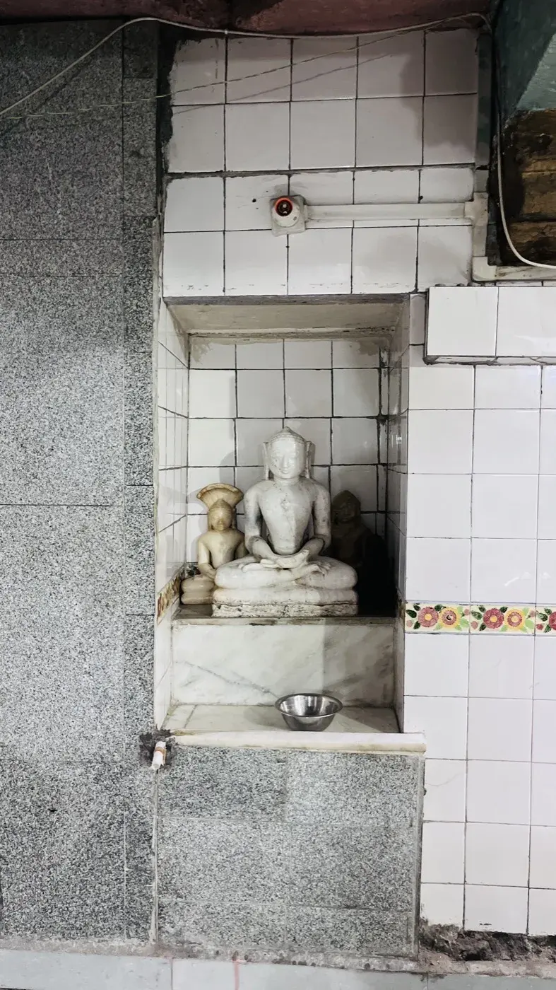 श्वेत संगमरमर की पद्मासन तीर्थंकर प्रतिमाओं की एक उप-देहरी, दोनों ओर छोटी यक्षिणी आकृतियों सहित, टाइल लगे कोनाड़े में स्थापित।